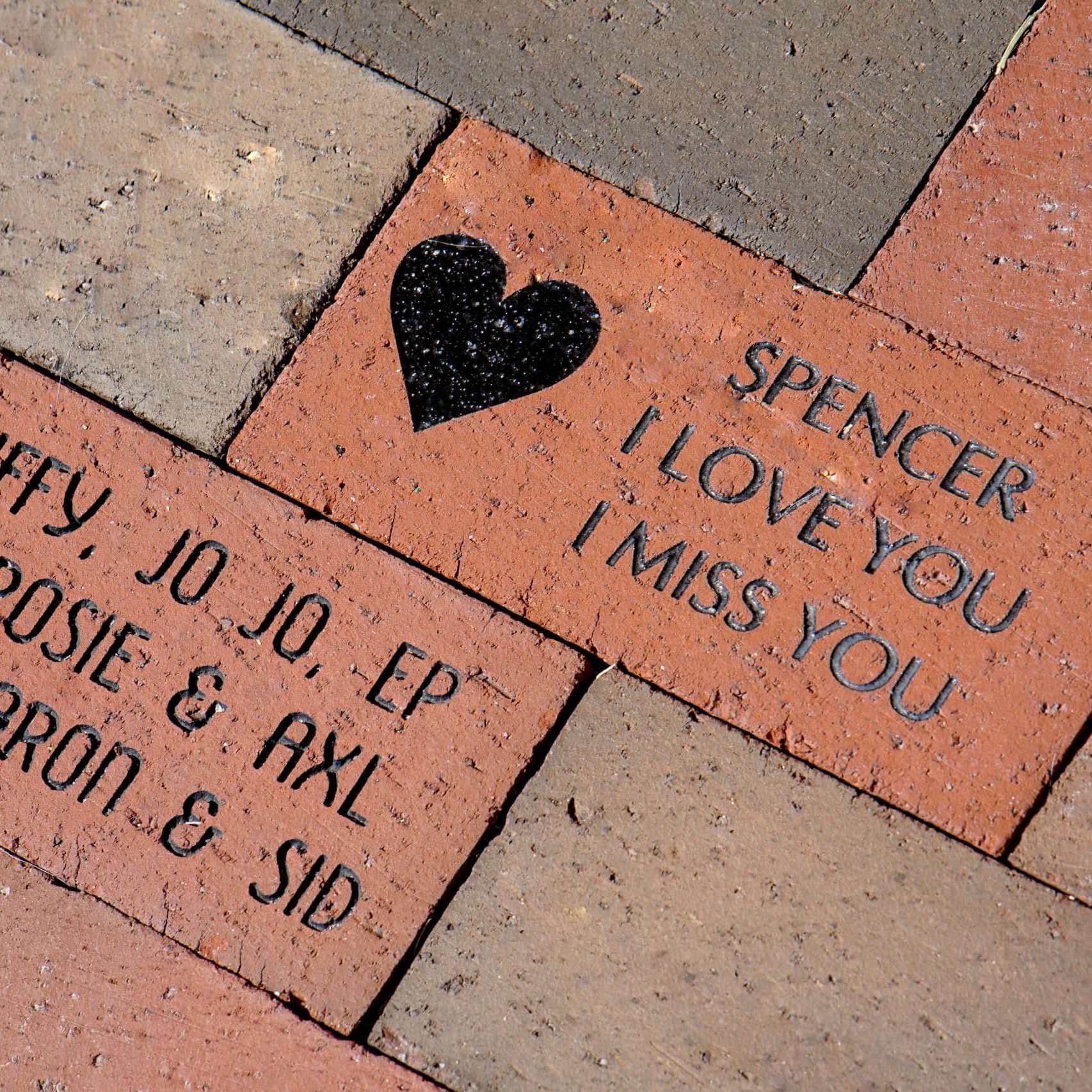 Engraved brick with love message for Spencer, saying "I love you" and "I miss you.".