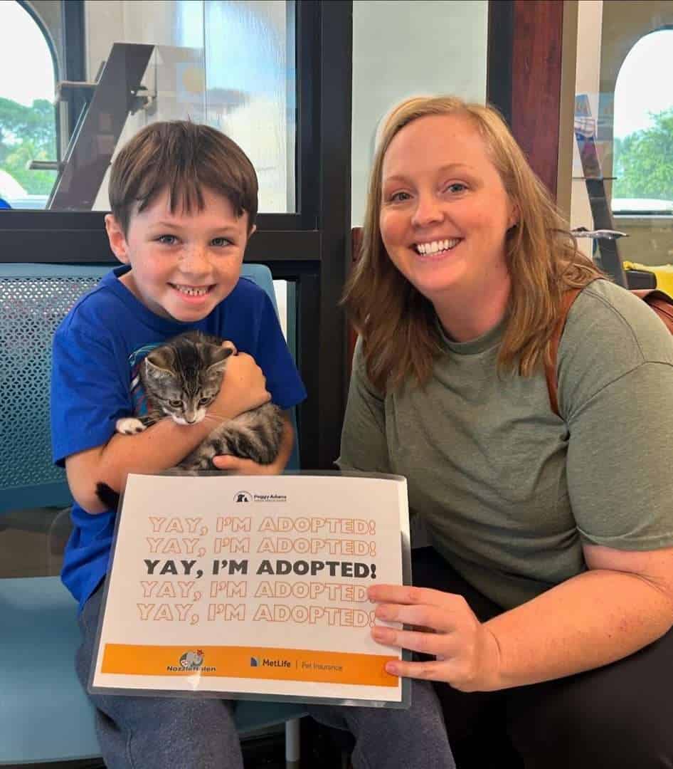 Adopted child and woman holding a cat at Peggy Adams Animal Rescue.
