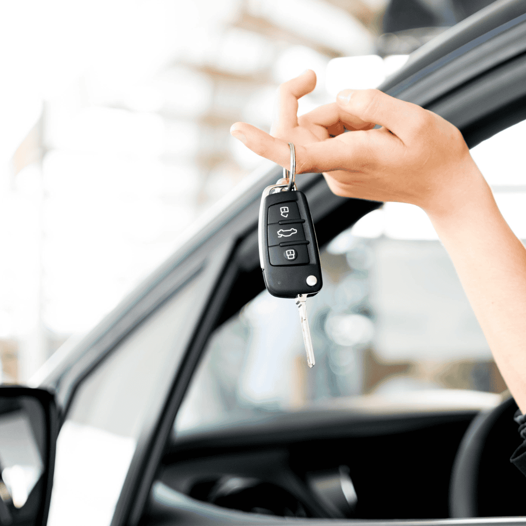 Person holding car key fob outside vehicle, close-up shot.