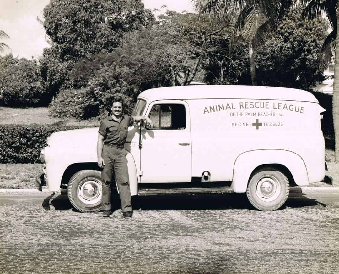 Animal rescue volunteer with vintage rescue truck.