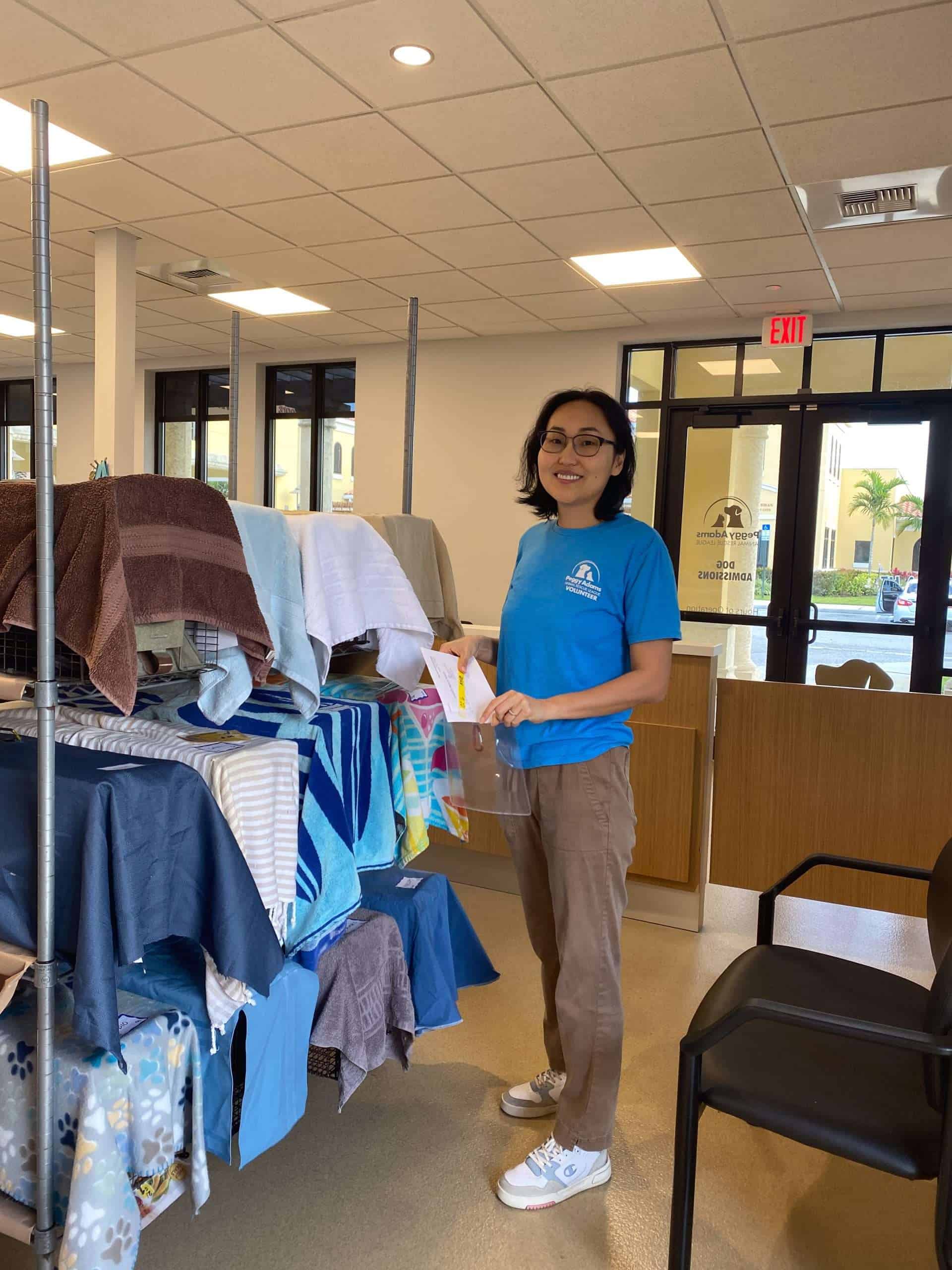 Woman organizing towels at Peggy Adams Animal Rescue shelter.